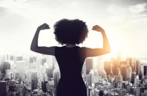 Rearview shot of an unrecognizable businesswoman standing and flexing her biceps while looking out of her high-rise office. How is Your Self-Esteem