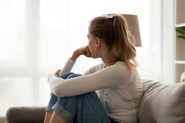 Side view young woman looking away at window sitting on couch at home. Frustrated confused female feels unhappy problem in personal life quarrel break up with boyfriend or unexpected pregnancy concept. Are You Worried? 4 Steps To Peace Of Mind