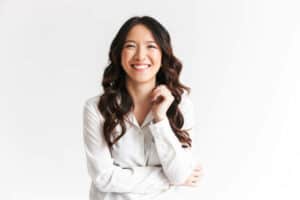 Portrait of gorgeous asian woman with long dark hair laughing at camera with beautiful smile isolated over white background in studio. 20 Ways to Make Someone Smile