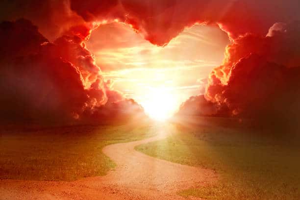 Red heart shaped sky at sunset. Beautiful landscape with road.Love background with copy space. Road to love.Only do what you love