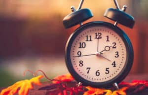 Alarm clock with fall leaves. Daylight savings time. Creating Amazing Days Each Day