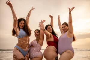 Portrait of a happy group of friends in the beach. Learning to love your curves