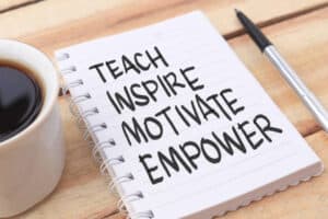 Teach inspire motivate empower, text words typography written on paper against the wooden background, life, and business motivational inspirational concept. The ultimate self-esteem.