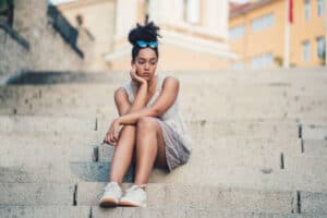 Unhappy young girl sitting on the steps outside. The ultimate self-esteem. 