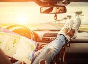 Young woman alone car traveler with map. Who's Driving On The Trip Of Your Life