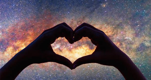 holding a heart with hands near the sky