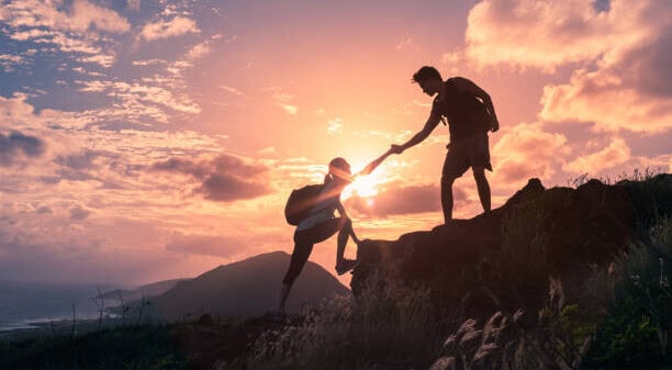woman hiking and holding a man hand 